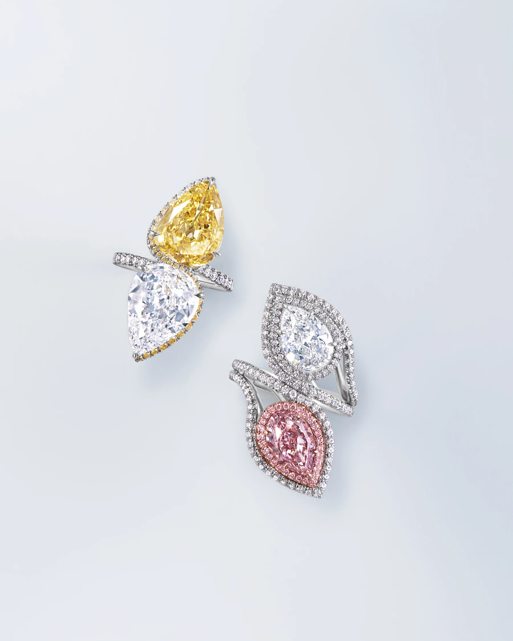 Two sculptural rings set with yellow, white, and pink pear-shaped diamonds