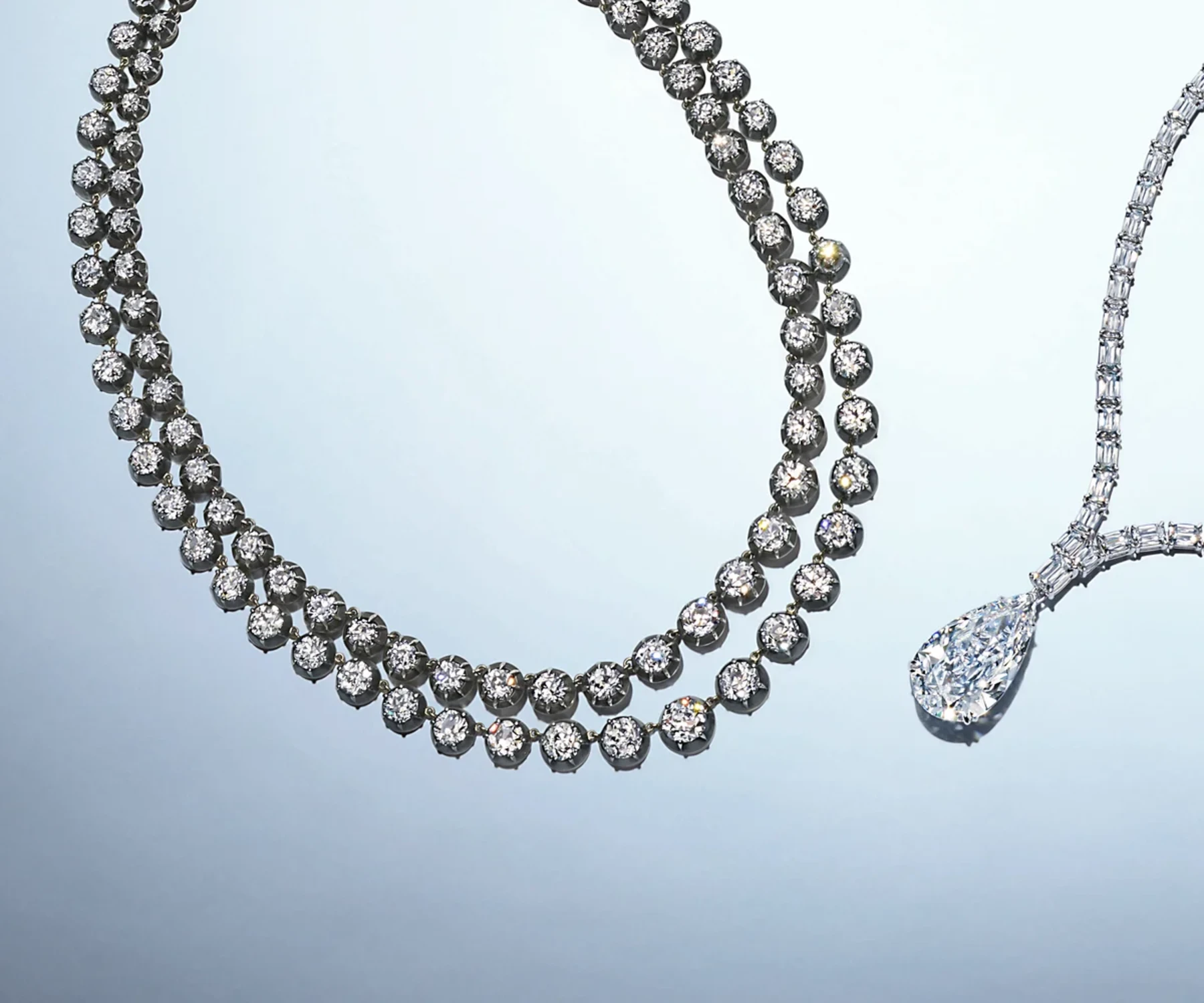 A substantial double-strand diamond necklace beside a large pear-shaped diamond pendant